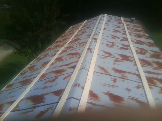 Rusted metal roof panels with new wood purlins before replacement — Storm Damage Roof Repair in Horton by Roofing Brothers