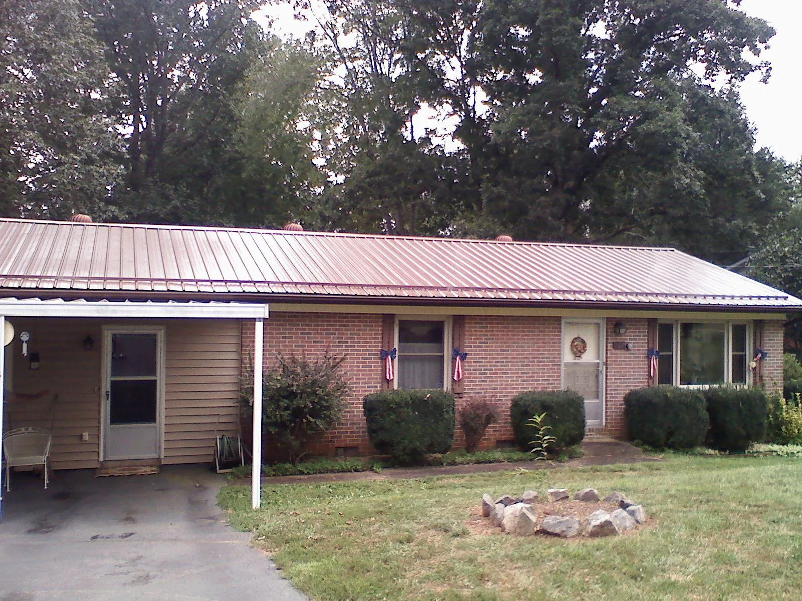 Bronze metal roof and carport on a brick ranch home — Roof Repair work by our crew in Horton